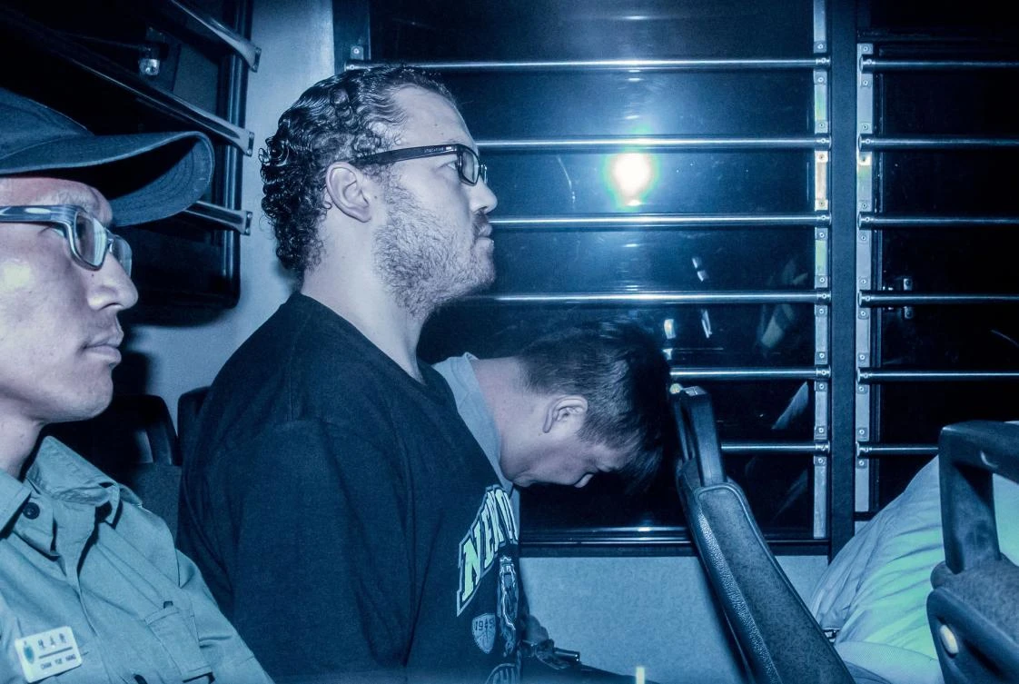 In this file picture taken on May 8, 2015, British banker Rurik Jutting (2nd L), accused of the murders of two Indonesian women, sits in a prison van as he arrives at the eastern court in Hong Kong. A British banker jailed for life for the horrifying 2014 murder of two Indonesian women at his upscale Hong Kong apartment in a cocaine-fueled rampage is to make an appeal bid on Dec. 12, 2017. (AFP/Anthony Wallace)