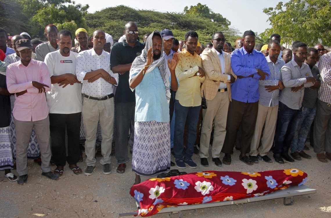 Mourners pray over the body of Somali journalist Mohamed Ibrahim, a news presenter for Kalsan TV, before his burial in Mogadishu, Somalia Tuesday, Dec. 12, 2017. Ibrahim died at a hospital late Monday after being injured by a bomb concealed in his car in Mogadishu’s Wadajir district, according to a fellow journalist who works for the same broadcaster. (AP/Farah Abdi Warsameh)