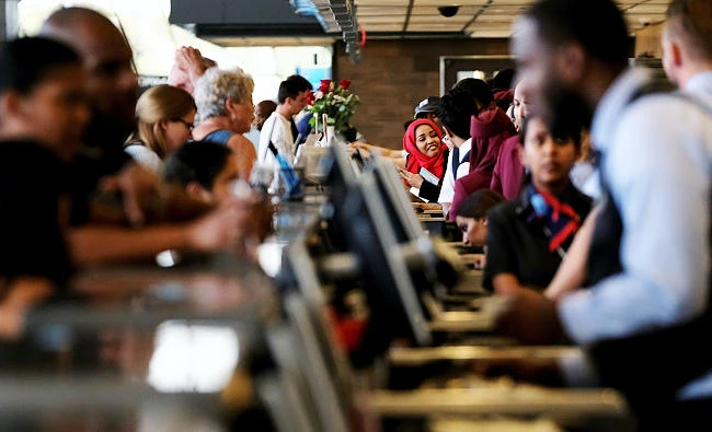 Airlines workers check passengers in for flights at the ticket counter at Dulles International Airport in Dulles, Virginia, U.S. in this September 24, 2017 photo. (REUTERS)
