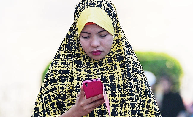 A woman uses her mobile phone. (AFP)