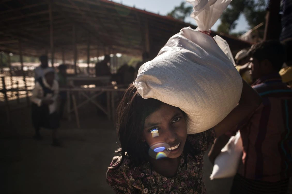A Rohingya migrant collects a sack of rice from a relief centre at the Balukhali refugee camp at Cox's Bazar on November 30, 2017. Rohingya are still fleeing into Bangladesh even after an agreement was signed with Myanmar to repatriate hundreds of thousands of the Muslim minority displaced along the border, officials said on November 27. (AFP)