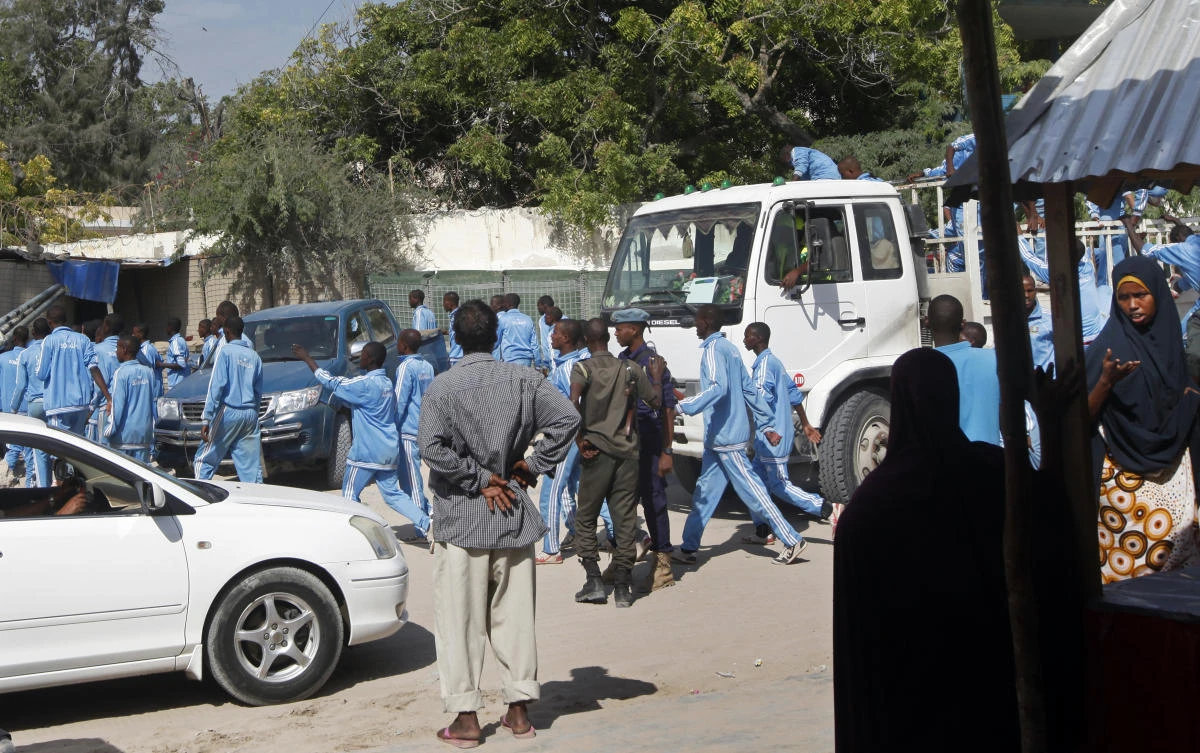 Somali police cadets arrive to help carry away the dead and injured following a suicide bomb attack on a police academy in Mogadishu on Thursday, December 14. (AP)