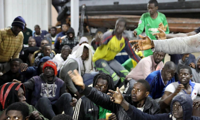 Migrants wait to receive food as they sit at Tripoli port after they were recused by Libyan coast guards, on Wednesday. (Reuters)