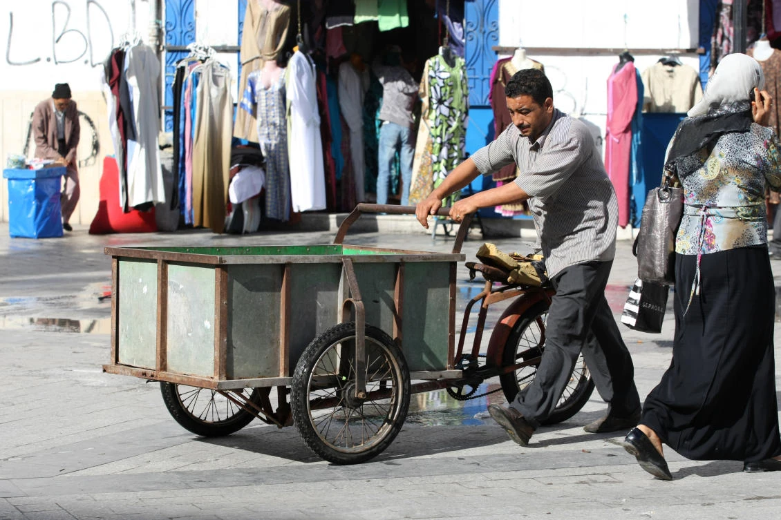 Man pushing a tricycle, refurbished bike that is intended for market in the medina, famous marketplace on September 14th, 2012 in Tunis,Tunisia. (Shutterstock)