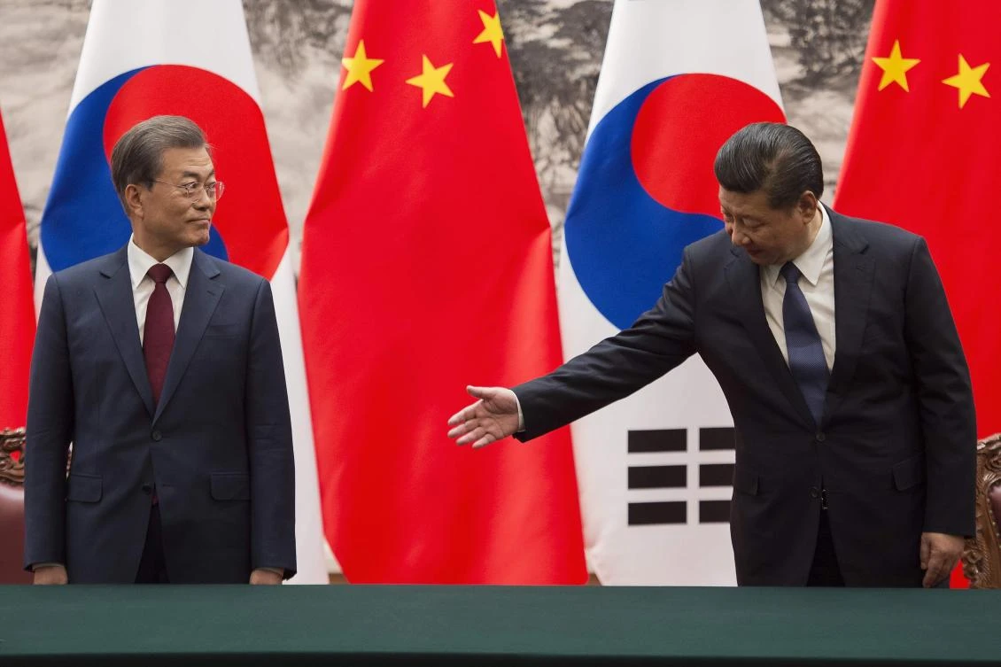 Chinese President Xi Jinping, right, gestures towards South Korean President Moon Jae-In during a signing ceremony at the Great Hall of the People in Beijing on December 14. (AFP)