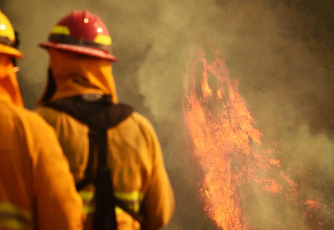 Firefighters keep an eye on flames as pockets of unburned vegetation flare up off Bella Vista Drive in Montecito, California. (Santa Barbara County Fire Department via AP)