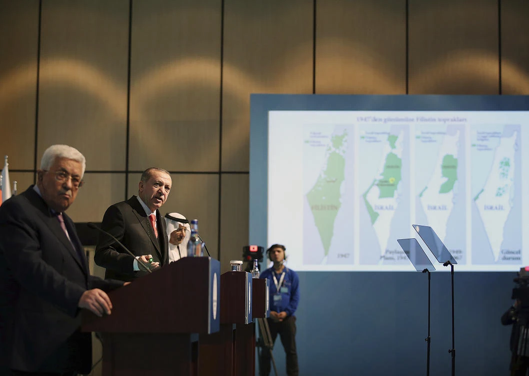 Backdropped by a map of Israel and Palestine, Turkey’s President Recep Tayyip Erdogan, 2nd left, talks during the closing news conference as Palestinian President Mahmoud Abbas, left, listens after the Organization of Islamic Cooperation’s Extraordinary Summit in Istanbul, Wednesday, Dec. 13, 2017. Muslim nations of the 57-member Organization of Islamic Cooperation are rejecting US President Donald Trump’s declaration of Jerusalem as the capital of Israel, and appear set to counter it with a declaration of east Jerusalem as the capital of a future Palestinian state. (Yasin Bulbul/Pool Photo via AP)