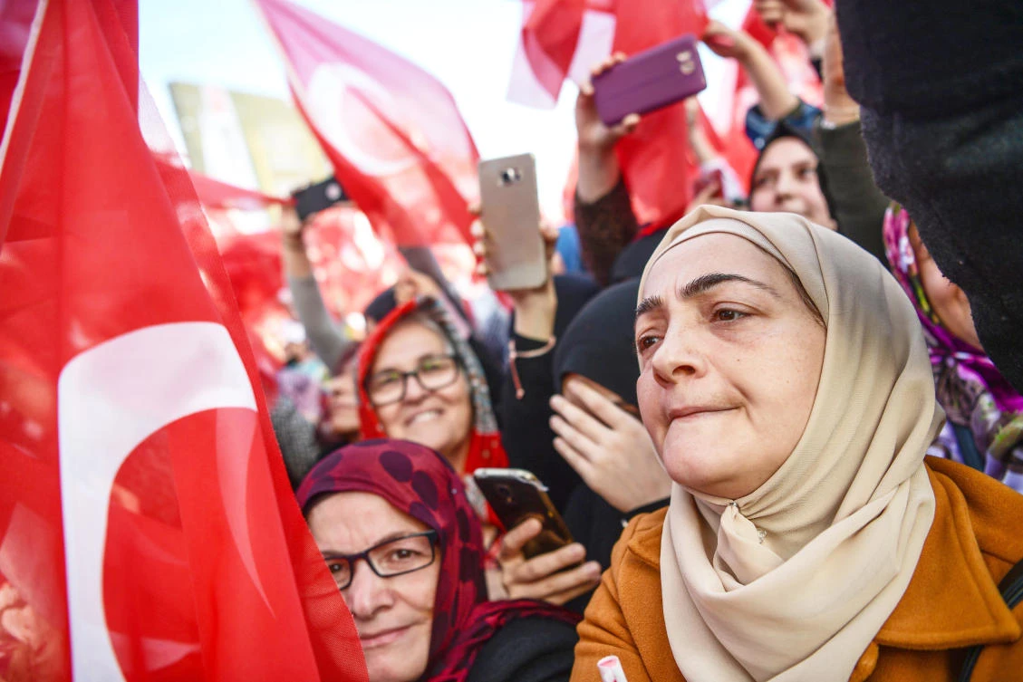 Supporters wave Turkish national flags during the inauguration ceremony of Turkey's first automated urban metro line on the Asian side of Istanbul. (AFP)