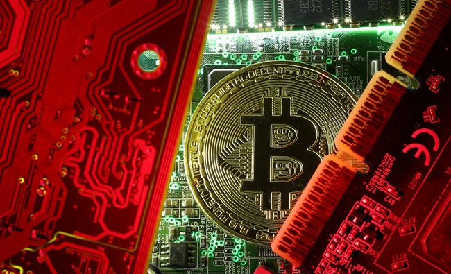 A coin representing the bitcoin cryptocurrency is seen on computer circuit boards in this illustration picture, in this October 26, 2017 photo. (REUTERS)