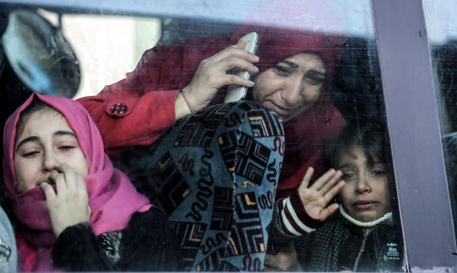 A Palestinian woman and child bid farewell through the window of a bus in Khan Younis in the southern Gaza strip on Saturday prior to their departure for the Rafah border crossing with Egypt. (AFP)
