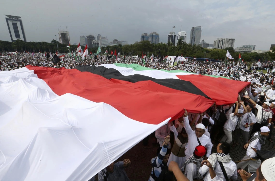 Protesters hold Indonesian and Palestinian flags during a rally in Jakarta against US President Donald Trump’s recognition of Jerusalem as Israel’s capital. An estimated 80,000 people rallied on Sunday in the 10th straight day of protests organized by the country’s top Muslim clerical body. (AP)
