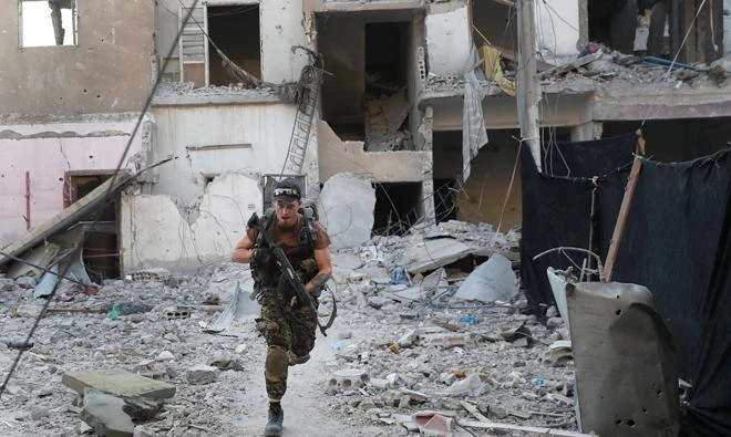 An anti-regime fighter crosses a street during clashes in Raqqa. (File photo/AP)