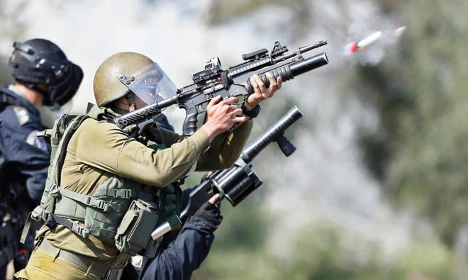 Israeli soldiers fire teargas canisters during clashes with Palestinian protesters in the West Bank town of Tulkarem on Sunday. (AP)