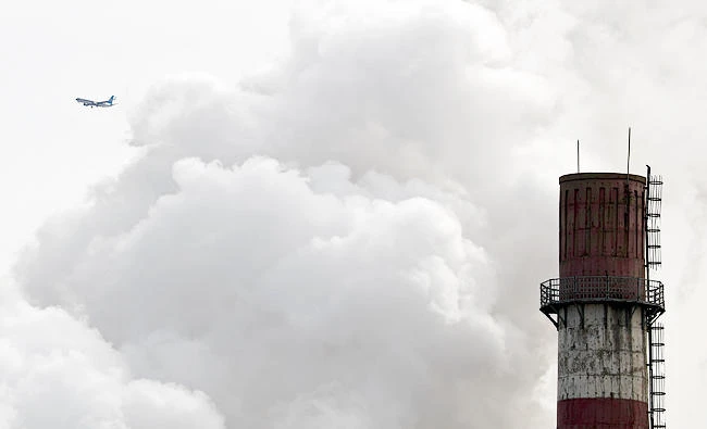 In this file photo taken Tuesday, Feb. 28, 2017, a passenger airliner flies past steam and white smoke emitted from China Huaneng Group's Beijing power plant that was the last coal-fired plant to shut down on March 18, 2017, as the Chinese capital convert to clean energy like thermal power. (AP)