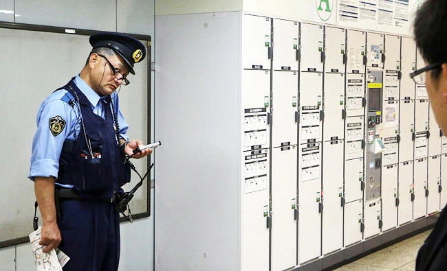 A police officer stands guard at a locker storage area at Tokyo station, in this file photo taken on June 1, 2015. (AFP)