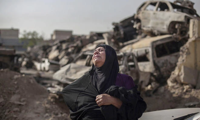 Fatima Ahmed Aswad cries, as the body of her 15-year-old daughter Sana is exhumed in Mosul for forensic investigation in order to receive a death certificate in this file photo. (AP)
