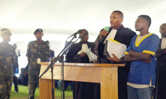 A defendant is introduced by a lawyer during the Kamwina Nsapu militia trial, at the Ndolo military prison, in Kinshasa, Democratic Republic of Congo, on Dec. 8. (Reuters)