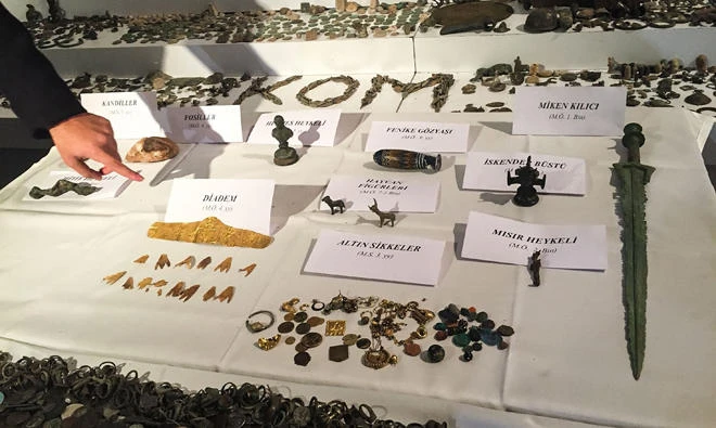 A Turkish police officer points to historical artifacts after police confiscated thousands of historical artifacts in a giant operation against smugglers in Istanbul, the private Dogan news agency reported on Thursday. (AFP)