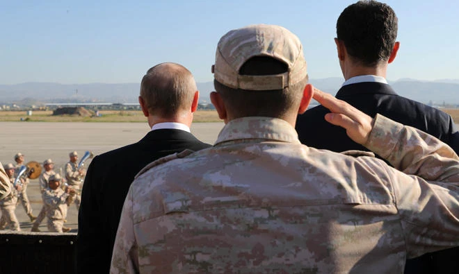 Russian President Vladimir Putin, left, and Syrian President Bashar Assad, right, watch the troops marching at the Hemeimeem air base in Syria, on Dec. 11, 2017. (AP)