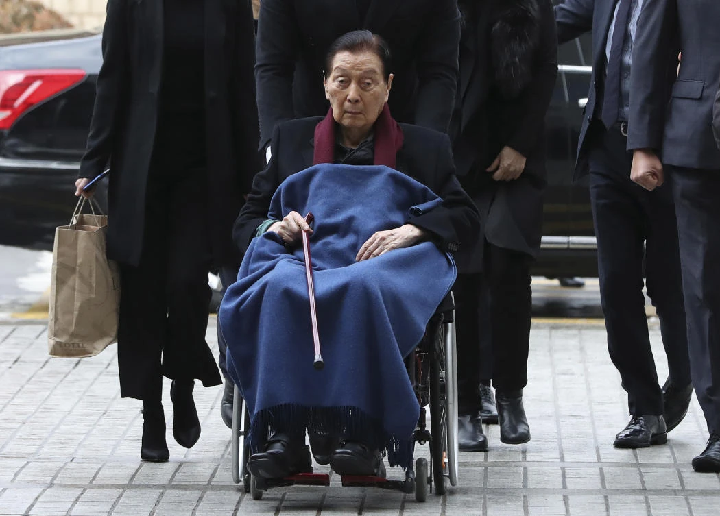 Lotte Group Founder Shin Kyuk-ho in a wheelchair, arrives at the Central District Court in Seoul, South Korea. The court convicted the 95-year-old and his son and group chairman on corruption charges. (AP)