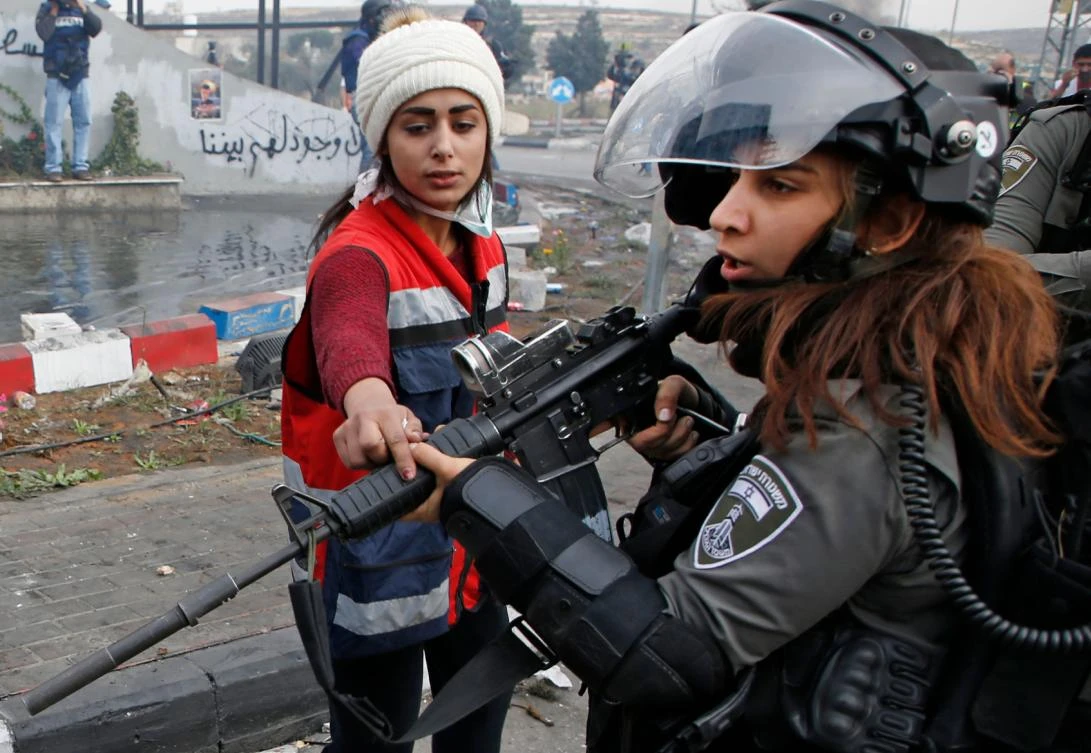 An Israeli border guard is confronted by a Palestinian protester during clashes north of Ramallah. (AFP)