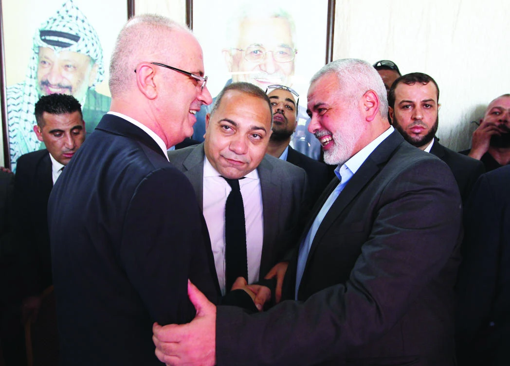 Hamas leader Ismail Haniyeh, right, shakes hands with Palestinian Prime Minister Rami Hamdallah inGazaCityonOct.3.(File/AFP)