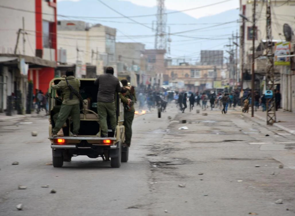 A picture taken on December 20, 2017 shows security forces riding in a vehicle as they chase down demonstrators in a street in the city of Raniya, 130 kilometres north of Sulaymaniyah in the autonomous Iraqi Kurdistan region, as protests against political corruption raged for a third day despite a clampdown by security forces after five people were killed. (AFP)