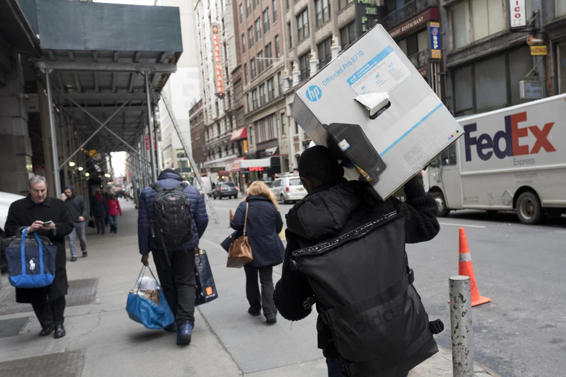 A delivery man carries a customer order as he leaves the Amazon Prime warehouse in New York. Bookstores are feeling the squeeze from Amazon’s incursions into their territory across the US. (AP)