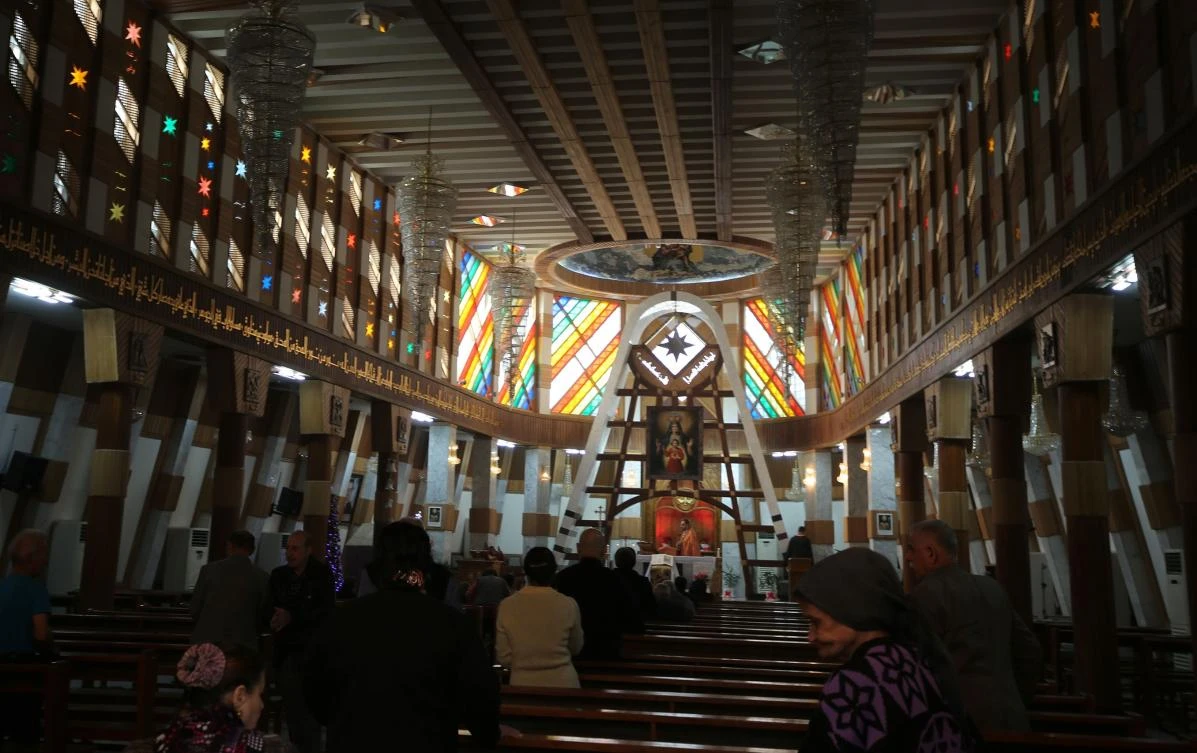 Above, Iraqis attend a Christmas mass at the Syriac Catholic Church of Sayedat Al-Najat in Baghdad. (AFP)