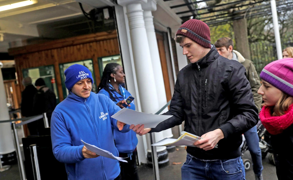 An employee checks tickets as customers enter London Zoo as it reopens following a fire which broke out at a shop and cafe at the attraction, in central London, Britain on Dec.24, 2017. (REUTERS)