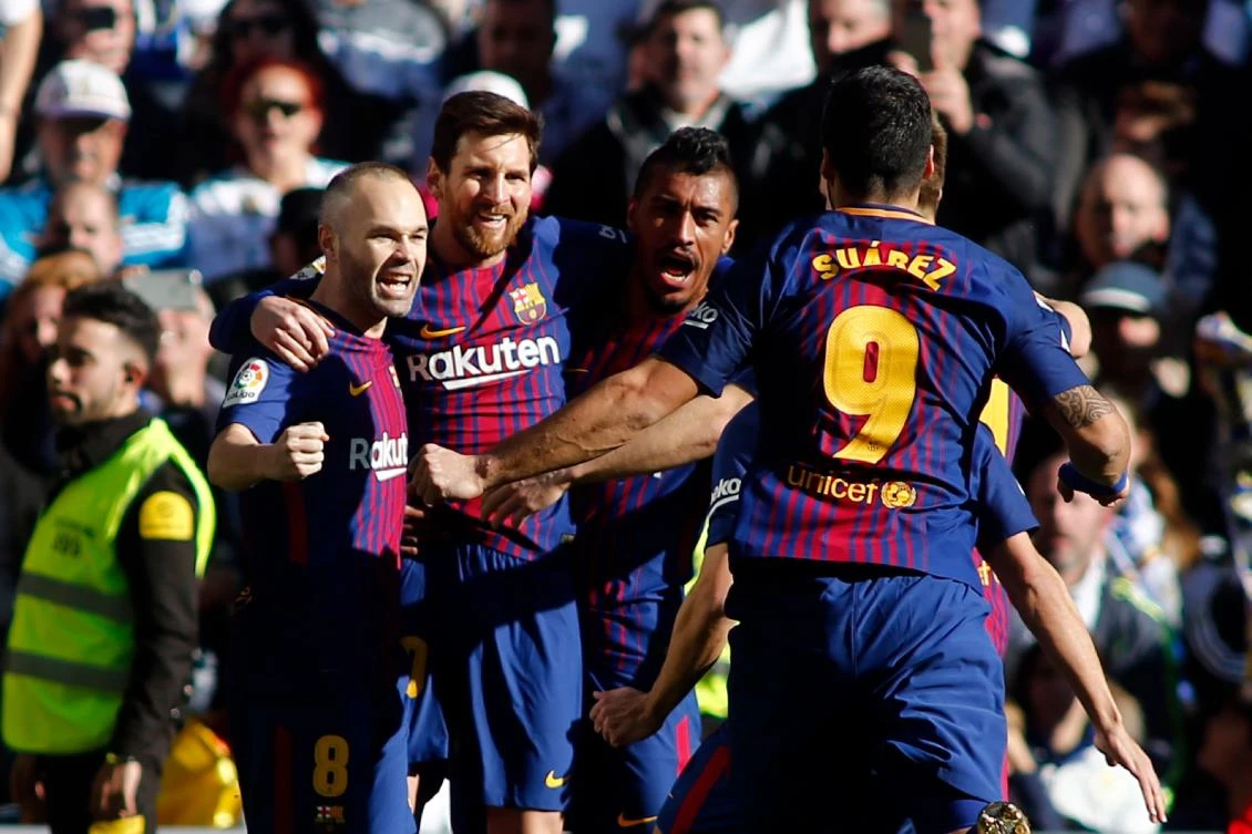Lionel Messi celebrates with Andres Iniesta, Paulinho and Luis Suarez after scoring against Real Madrid on Saturday. (AFP)