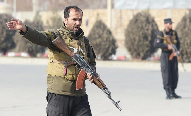 An Afghan policeman shouts as he keeps watch at the side of an ongoing attack in Kabul, in this December 18, 2017 photo. (AFP)