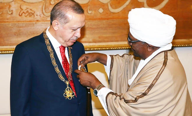 Sudan's President Omar al-Bashir, right, presents Turkey's President Recep Tayyip Erdogan with his country's highest medal during a ceremony in Khartoum, Sudan, on Sunday. (AP)