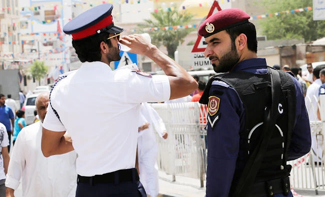 A Bahraini police officer takes a drink of water while standing with a riot policeman outside of a Shiite mosque in Manama, Bahrain, in this June 5, 2015 file photo. (AP)