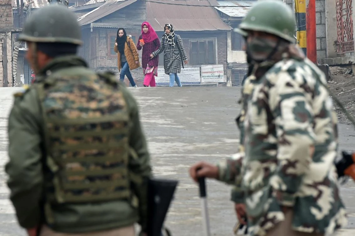 Indian paramilitary troopers stands guard as Kashmiri women walk during a one day strike in Srinagar on December 20, 2017. (AFP)