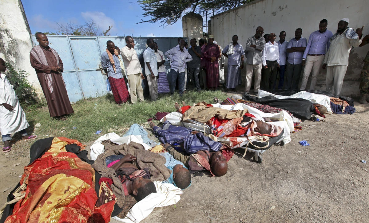 In this Friday, Aug. 25, 2017 file photo, Somalis observe bodies which were brought to and displayed in the capital Mogadishu, Somalia, following a raid by foreign and Somali forces on a farm in Bariire village in southern Somalia. A spokesman for U.S. Africa Command said Wednesday, Dec. 13, 2017 that its head Marine Gen. Thomas Waldhauser has asked the Naval Criminal Investigative Service to look into whether civilians were killed during the raid by Somali troops supported by U.S. special operations forces. (AP)