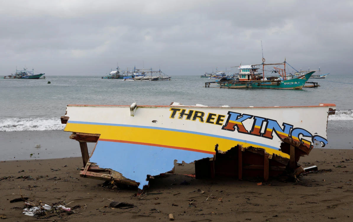 The remains of a passenger boat capsized during a typhoon is pictured overlooking passenger boats near the shore. (Reuters)