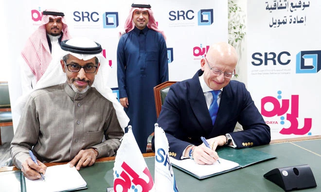Fabrice Susini (from right) of Saudi Real Estate Refinance Company signs the deal with Mazin Al-Ghunaim of Bidaya Home Finance, in front of Saudi Housing Minister Majed Al-Hogail and Abdul Aziz Saleh Al-Omair of Bidaya. (SRC)