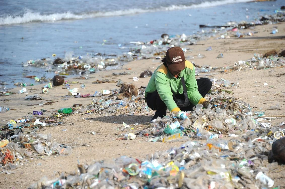 This photo taken on December 19, 2017 shows a rubbish collector clearing trash on Kuta beach near Denpasar, on Indonesia’s tourist island of Bali. (AFP)