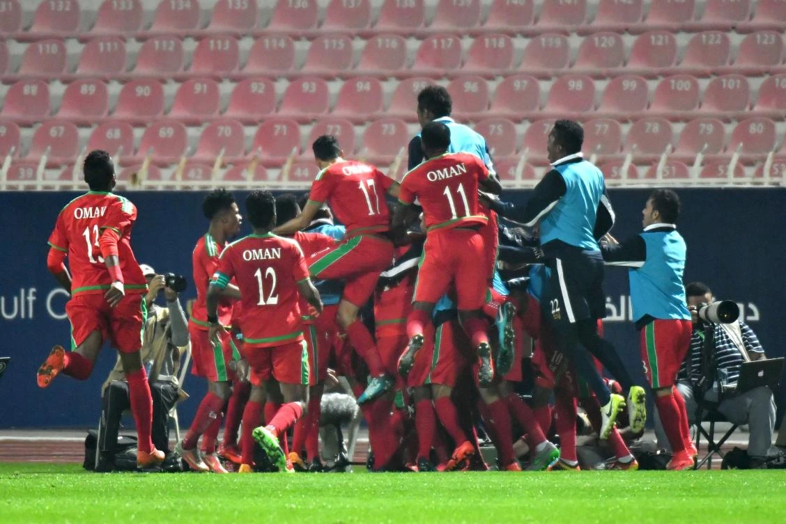 Oman's team celebrate after scoring a goal during the 2017 Gulf Cup of Nations football match between Saudi and Oman at the Kuwait Stadium in Kuwait City on December 28, 2017. / AFP / GIUSEPPE CACACE
