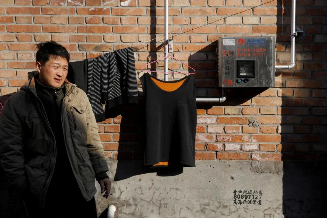 Above, a resident stands next to a newly installed gas meter in Xiaozhangwan village at the outskirts of Beijing. China is also struggling to build the infrastructure needed to freely distribute gas supplies. (Reuters)