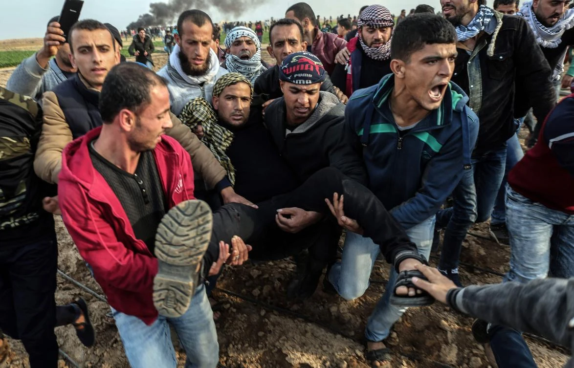 Palestinian protesters carry a wounded comrade during clash with Israeli forces near the Israel-Gaza border east of the southern Gaza strip city of Khan Yunis. (AFP)