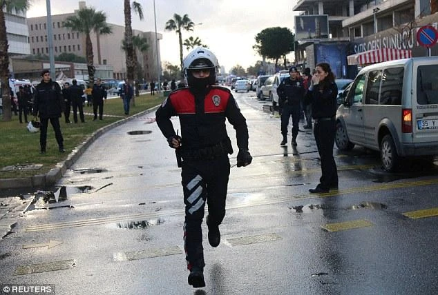 A police officer runs down the road as emergency services descend on the scene in Izmir. (REUTERS)