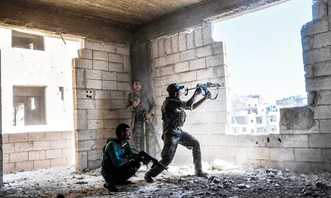 Members of anti-Assad forces fire at their rival militants in Raqqa. (File photo/AFP)