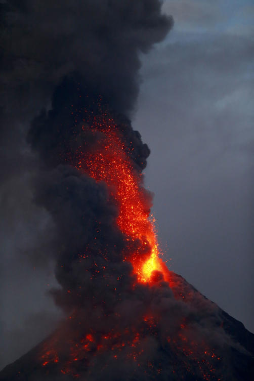 Mayon volcano spews red-hot lava in another eruption as seen from Legazpi city, Albay province around 200 miles (340 kilometers) southeast of Manila, Philippines Tuesday, Jan. 23, 2018. The Philippines' most active volcano spewed fontains of red-hot lava and massive ash plumes in a dazzling but increasingly dangerous eruption that has sent thousands villagers fleeing to evacuation centers.(AP Photo/Bullit Marquez)