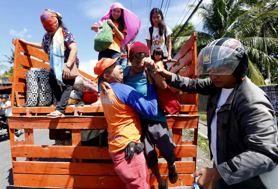 Residents living within the 9-kilometer (5.6-mile) radius around Mayon volcano are evacuated to safer grounds as Mayon continues to erupt for the second straight day Tuesday, Jan. 23, 2018 in Legazpi city, Albay province, southeast of Manila, Philippines. The Philippines' most active volcano continued to spew fountains of red-hot lava and massive ash plumes Tuesday in a dazzling but increasingly dangerous eruption that has sent 40,000 villagers to shelter in evacuation centers. (AP Photo/Bullit Marquez)
