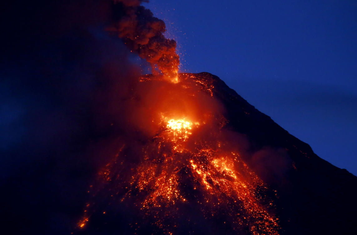 Mayon volcano spews red-hot lava in another eruption as seen from Legazpi city, Albay province, roughly 200 miles (340 kilometers) southeast of Manila, Philippines, Tuesday, Jan. 23, 2018. Mayon has spewed fountains of red-hot lava and massive ash plumes anew in a dazzling but increasingly dangerous eruption that has sent 56,000 villagers fleeing to evacuation centers. (AP Photo/Bullit Marquez)