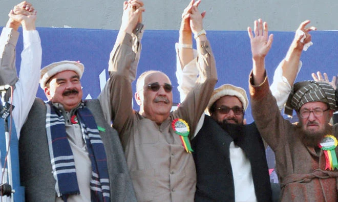 Palestinian ambassador to Pakistan, Walid Abu Ali, second left, raises jointly hands with Hafiz Saeed, second right, the head of the hard-line Jamaat-ud-Dawa, and others during an anti-US rally in Rawalpindi on Friday. (AP)