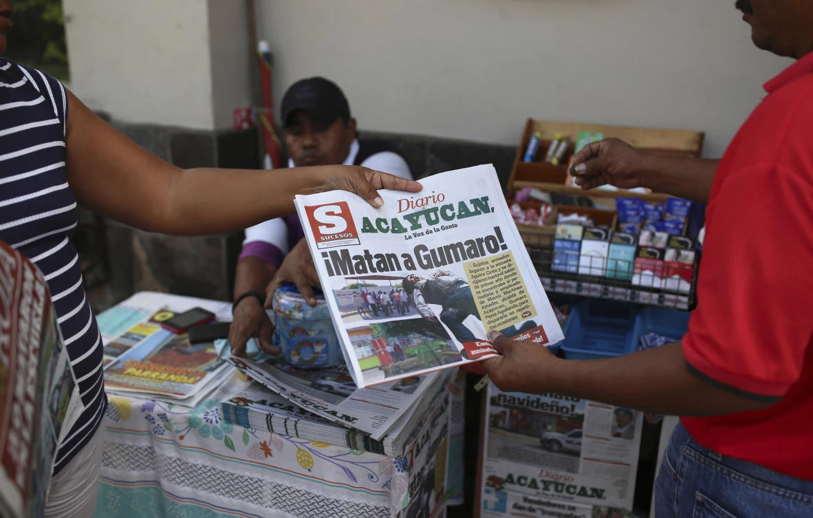 A man buys a newspaper carrying the Spanish headline “They killed Gumaro!” on the sidewalk in Acayucan, Veracruz state, Mexico. For some, Gumaro Perez was an experienced reporter who earned the nickname “the red man” for his coverage of bloody crimes in Acayucan, Veracruz, but in the eyes of prosecutors he was an alleged drug cartel operative who met a grisly end when he was shot dead Dec. 19. (AP/Felix Marquez, File)