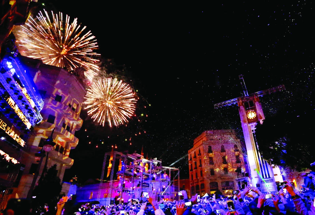 People watch fireworks in the rain on New Year's Day in downtown Beirut on Monday. (Reuters)